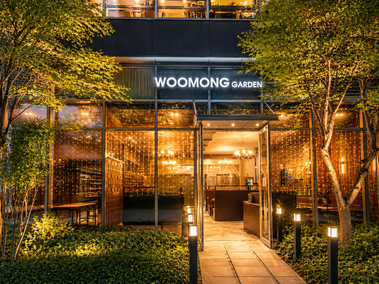 Woomong Garden Pangyo at night, lit entrance through trees